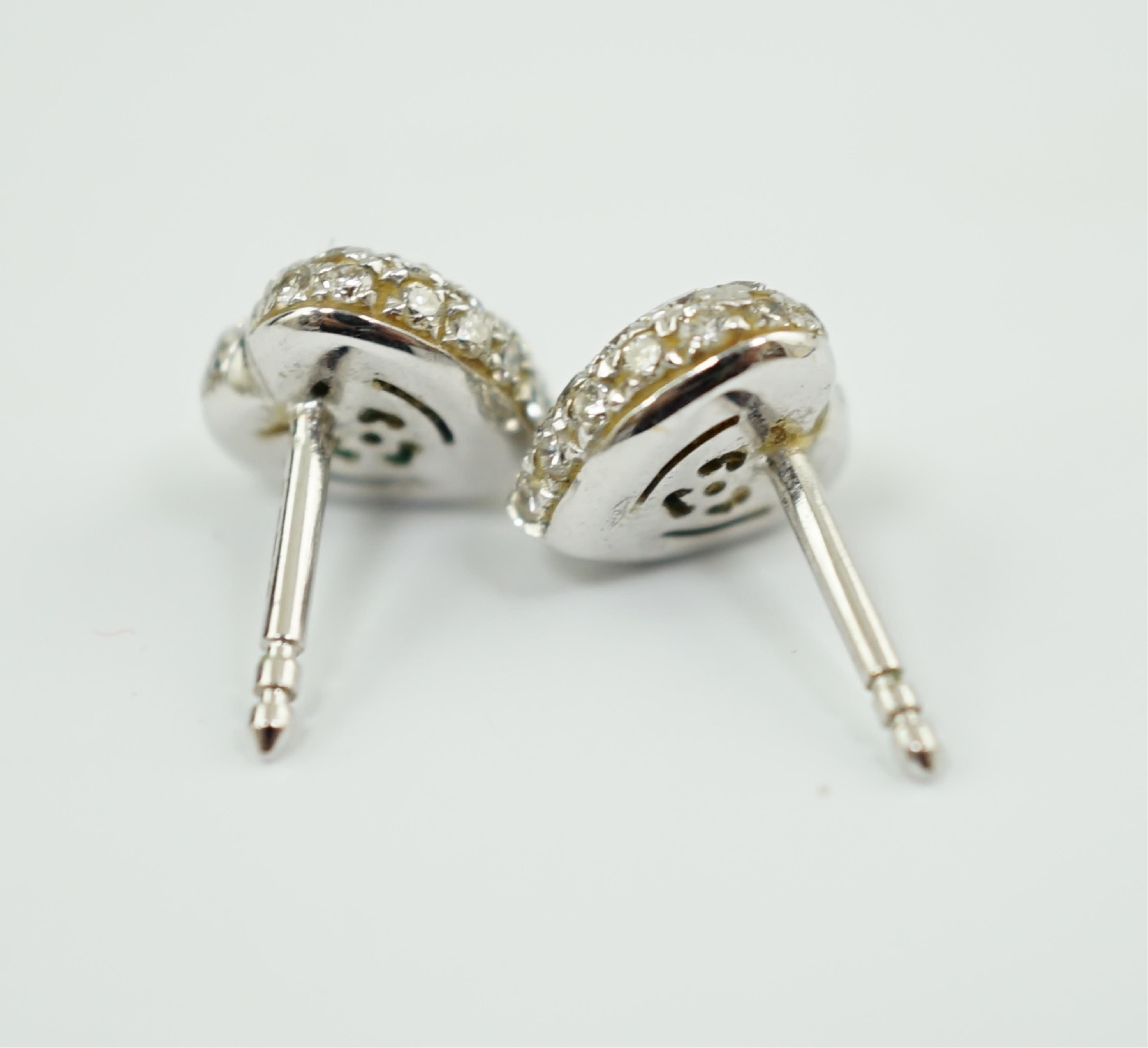 A modern pair of 18ct white gold, emerald and diamond set heart shaped cluster ear studs